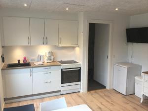 a kitchen with white cabinets and a stove top oven at Billund Center Apartment in Billund