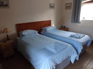 twee bedden naast elkaar in een slaapkamer bij Peartree Farm in Aldwincle Saint Peter