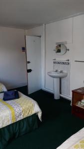 a hotel room with a bed and a sink at Victoria Inn in Alston