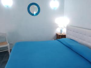 ネットゥーノにあるAppartamento vista mareのベッドルーム(青いベッド1台、鏡付)
