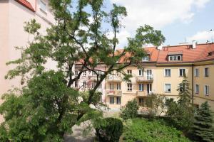 un edificio con un árbol delante de él en MARIENSZTAT - VIEW 2, en Varsovia