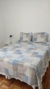 uma cama com cobertores e almofadas azuis e brancos em Village Copacabana no Rio de Janeiro