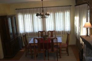 Un comedor con una mesa y sillas y una lámpara de araña. en Casa De Campo El Corzo, en Sotillo de la Adrada