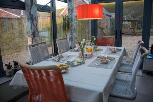 a dining room table with a white table cloth and chairs at St Leonards Farmhouse in Blandford Forum