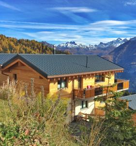 貝特默阿爾卑的住宿－Chalet la cordée，小木屋设有阳台,享有山脉的背景