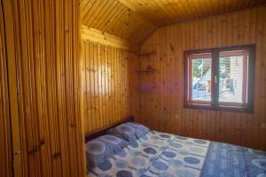 una camera da letto con un letto in una cabina di legno di Guest house Jezera a Žabljak