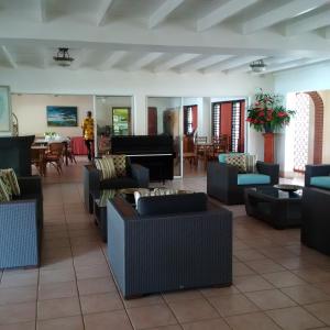 a lobby with couches and tables and a piano at Sunset Shores Beach Hotel in Kingstown