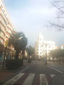 eine leere Stadtstraße mit Palmen und Gebäuden in der Unterkunft Carol's home in Saragossa