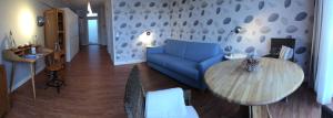 ein Wohnzimmer mit einem blauen Sofa und einem Tisch in der Unterkunft Port Sea Shell in Eckernförde