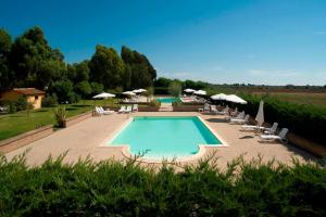 a swimming pool with lounge chairs and umbrellas at Agriturismo Le Pescine in Vada