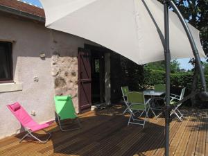 un patio con mesa, sillas y sombrilla en Le Beauvais, son gîte, ses chambres en Bourgogne, en Saint-Saulge