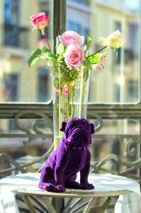 a purple teddy bear sitting next to a vase of roses at Purple Dog Suites in León