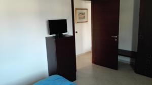 a bedroom with a bed and a television on a dresser at Casa la rosa dei venti in Cardedu