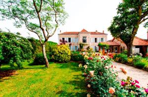 una casa con un jardín con flores delante en L'Isle de Bourbon, en Le Gué-de-Velluire