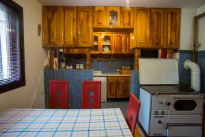 a kitchen with wooden cabinets and red doors and a table at Guest house Jezera in Žabljak