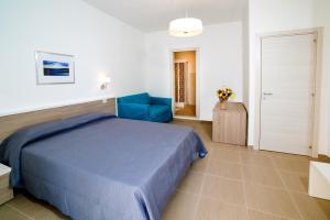 una camera da letto con un letto blu e una sedia di Hotel Caudullo a Letoianni