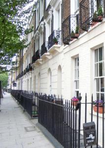 ロンドンにあるKings Cross Apartmentsの白い建物の前の黒い柵