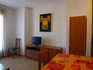 Una televisión o centro de entretenimiento en Apartamentos Puerta Muralla