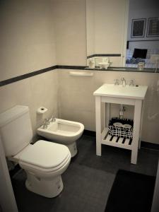 a bathroom with a white toilet and a sink at Petite Maison in Buenos Aires