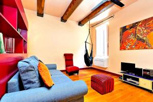 a living room with a blue couch and a tv at delCINQUE 26 - Loft in Trastevere in Rome