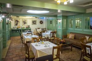 City Hotel Apollonion في كاربنيسي: مطعم بطاولات وكراسي وأريكة