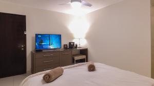 Schlafzimmer mit einem Bett und einem Flachbild-TV in der Unterkunft Luxury Suite by the pool in Eilat