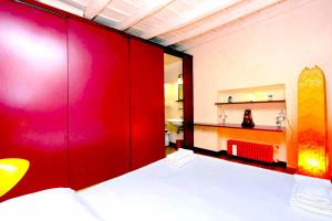 a bedroom with a bed and a red wall at delCINQUE 26 - Loft in Trastevere in Rome