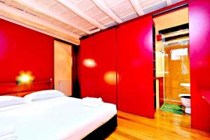 a red bedroom with a bed and a toilet at delCINQUE 26 - Loft in Trastevere in Rome