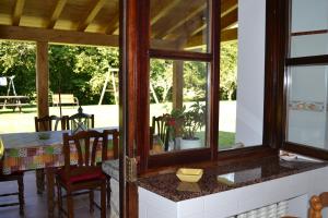 a kitchen with a table and chairs and windows at El Molin De Frieras in Posada de Llanes