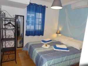 1 dormitorio con 2 camas y cortina azul en Fisherman's Palace, en Olhão