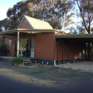 a small house with ducks standing outside of it at Glenfield Cottage in Yarck