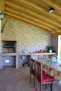 uma cozinha com uma mesa e cadeiras e uma lareira em El Molin De Frieras em Posada de Llanes