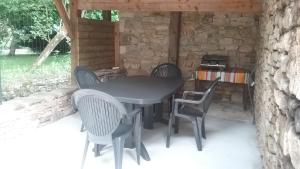 uma mesa preta e cadeiras num pátio em Gite D Aureilles em Gramat
