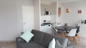 een woonkamer met een bank en een tafel en een keuken bij Résidence MONTE CARLO in Châtelaillon-Plage