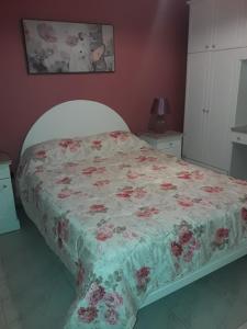 a bedroom with a bed with a floral bedspread at Bonne Vie in Xlendi