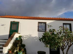 マダレナにあるCasa dos biscoitosの緑のドアと階段のある白い家