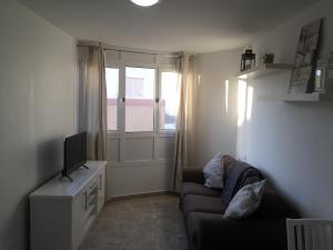a living room with a couch and a television at Sol y mar in Arinaga