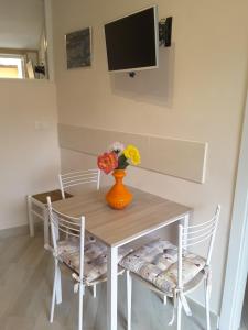 - une table à manger avec un vase de fleurs dans l'établissement Appartamento Poggio Romantico Andrea, à Marciana