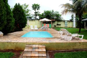 una piscina con sedie, tavolo e ombrellone di Pousada Akonxego a Olímpia Altre 28 foto