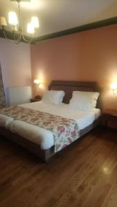 a bedroom with a large bed with white sheets and pillows at Hotel Pelasgos in Karitaina +22 photos