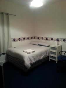 ein Schlafzimmer mit einem großen Bett mit einer weißen Decke in der Unterkunft Double Room Home Stay Manchester in Manchester