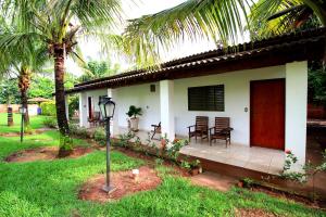 una casa bianca con tavolo e sedie in cortile di Pousada Akonxego a Olímpia