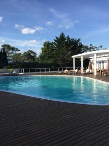 una piscina de agua azul y un pabellón en Edificio Isabel, en Punta del Este