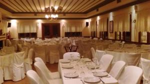 a banquet hall with white tables and white chairs at Hotel Pelasgos in Karitaina