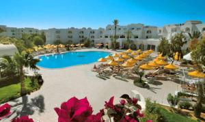 una vista sul tetto di una piscina del resort con ombrelloni e sedie di Iris Hotel & Thalasso a Taguermess