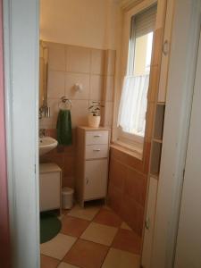 La petite salle de bains est pourvue d'un lavabo et de toilettes. dans l'établissement ÁRPÁD Apartman, à Szekszárd