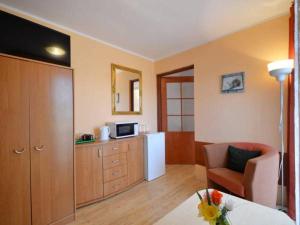 a room with a kitchen with a chair and a microwave at Villa Christina in Mielno