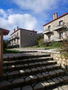 a stone path in front of two buildings at Hotel Pelasgos in Karítaina