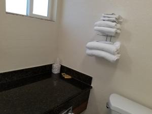 Baño con una pila de toallas en una encimera en Buckboard Motel en Santa Maria