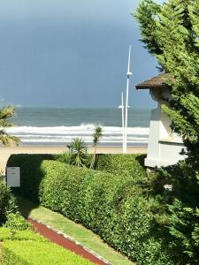 Blick auf den Strand mit einem Haus und Windturbinen in der Unterkunft Ibaia Sokoburu dream in Hendaye